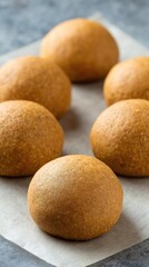 Unbaked whole-wheat dough balls on parchment paper