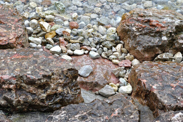 Close Up of Rocks Pebbles and Lapping Clear Water on Lakeside Beach 