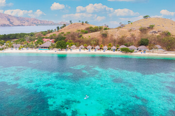 Summer adventure with man paddle boarding in crystal clear tropical sea, perfect for travel and holiday stock.