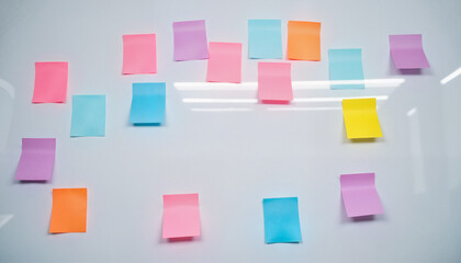 Colorful sticky notes arranged on a whiteboard in an office space -  