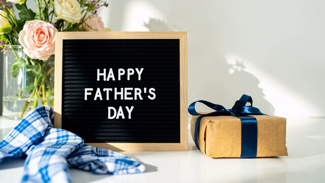 Happy Father's Day chalkboard frame with gift items and flowers - Powered by Adobe