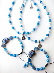 Blue stone kyanite aquamarine apatite beaded bracelets and chokers with eye charms flat lay top view close up. Natural semiprecious stone jewelry, accessories, fashion collection, crafts, jewellery