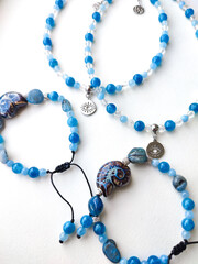 Blue stone kyanite aquamarine apatite beaded bracelets and chokers with eye charms flat lay top view close up. Natural semiprecious stone jewelry, accessories, fashion collection, crafts, jewellery