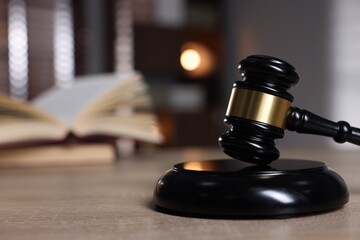 Judge's gavel and sound block on wooden table against blurred background, closeup. Space for text