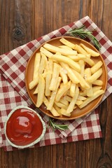 Tasty french fries served with ketchup and rosemary on wooden table, top view