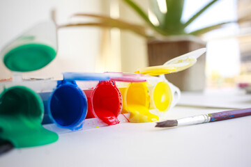 Paint brushes and paint cans on white paper