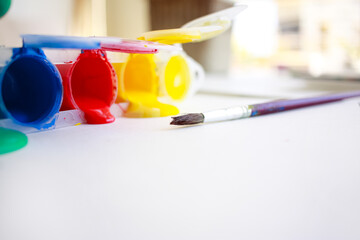 Paint brushes and paint cans on white paper