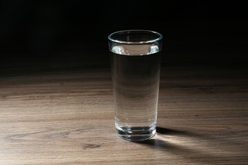 Fresh water in glass on wooden table