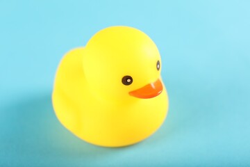 One cute rubber duck on light blue background, closeup