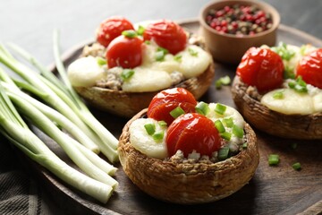Tasty stuffed mushrooms served on black table, closeup