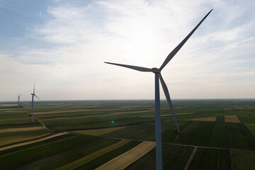 Aerial view of wind turbine on an agricultural filed at sunset. Close up of blades