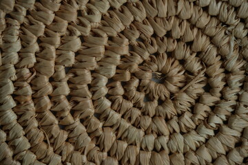round macro texture of summer brown paper hat as background, round close up texture of panama hat, panama hat paper