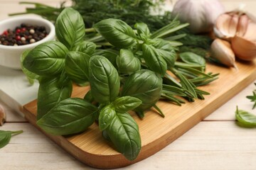 Different fresh herbs and spices on white wooden table, closeup