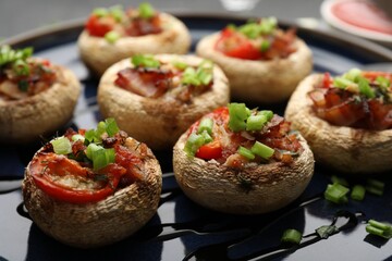Tasty stuffed mushrooms served on black table, closeup
