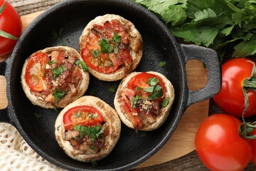Tasty stuffed mushrooms served on wooden table, flat lay