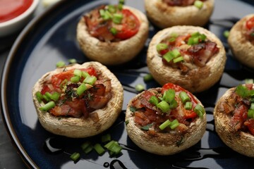 Tasty stuffed mushrooms served on black table, closeup