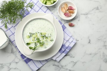 Tasty cucumber soup with dill, microgreens and ingredients on white marble table, flat lay