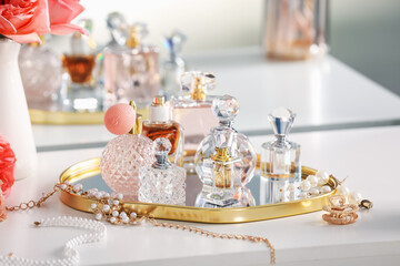 Bottles of different perfumes and accessories on dressing table indoors