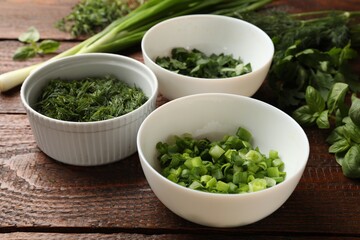 Different fresh herbs on wooden table, closeup