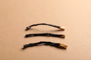 Burnt matches on beige background, closeup view
