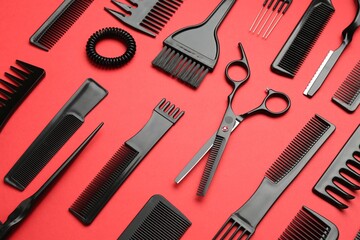 Different hairdresser's tools on red background, above view