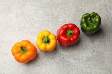 Fresh colorful bell peppers on gray textured table, flat lay