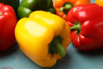 Fresh colorful bell peppers on blue wooden table, closeup