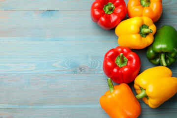 Fresh colorful bell peppers on blue wooden table, flat lay. Space for text