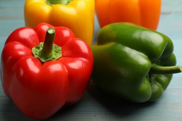Fresh colorful bell peppers on blue wooden table, closeup