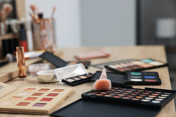 Different makeup products and brush on vanity indoors, closeup