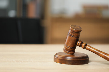 Judge's gavel on wooden table in office, closeup. Space for text