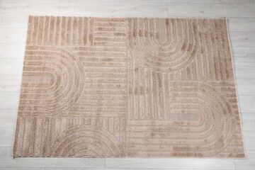 Stylish rug with pattern on light wooden floor, top view