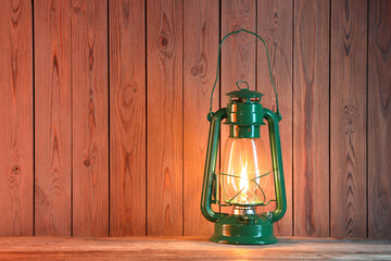 One vintage kerosene lantern on wooden table, space for text