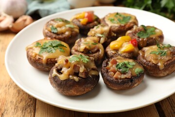 Tasty stuffed mushrooms on wooden table, closeup