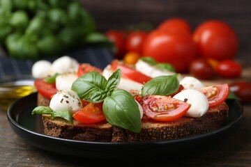 Tasty sandwiches with mozzarella cheese, tomatoes, basil and spices on wooden table, closeup
