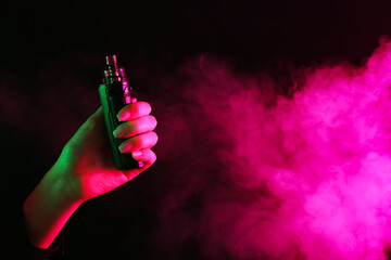 Woman using electronic smoking device in neon lights on black background, closeup. Space for text