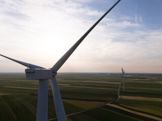 Aerial view of wind turbine on an agricultural filed at sunset. Close up of blades