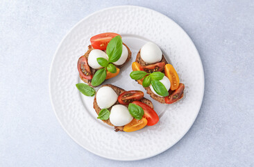 Tasty sandwiches with mozzarella cheese, tomatoes and basil on white table, top view