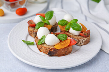 Tasty sandwiches with mozzarella cheese, tomatoes and basil on white table, closeup