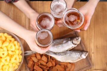 Friends with beer and snacks at wooden table, top view
