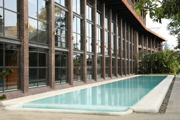 Outdoor swimming pool and green plants near building at luxury resort
