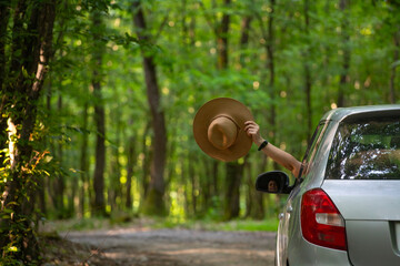 Girl with hat in the window of the car. Adventure, vacation, road trip concept.