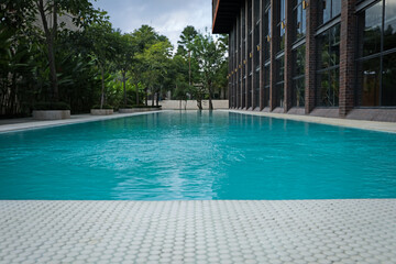 Outdoor swimming pool and green plants near building at luxury resort, closeup