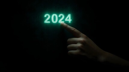 Glowing 2024 digit touched by human finger in the dark