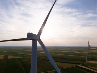 Aerial view of wind turbine on an agricultural filed at sunset. Close up of blades