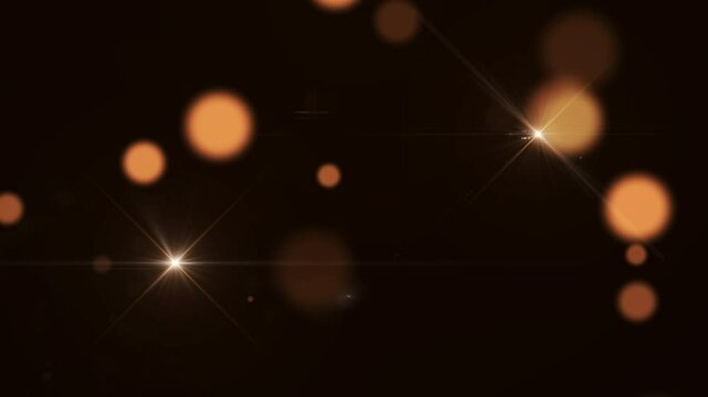 Glowing orange and white lens flares with soft bokeh effects on a dark background
