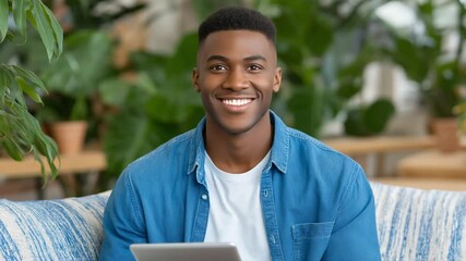 Smiling young man using a tablet in a cozy casual workspace