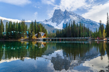 Idyllic Emerald Lake in Yoho National Park with snow-capped mountains and pine forests with charming lodge reflected in the turquoise water in Alberta, Canada