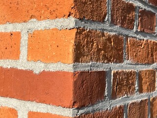 brick wall corner, red brickwall with cement fill closeup for background