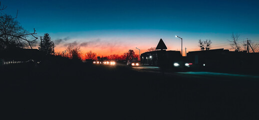 Evening sky casts an orange and blue glow over the city landscape. © Andrii_Abriutin